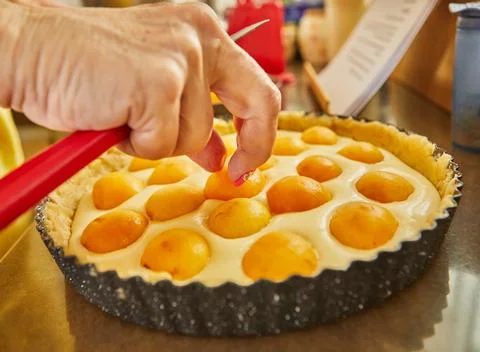 Chef puts apricots in pie to bake in the oven Stock Photos