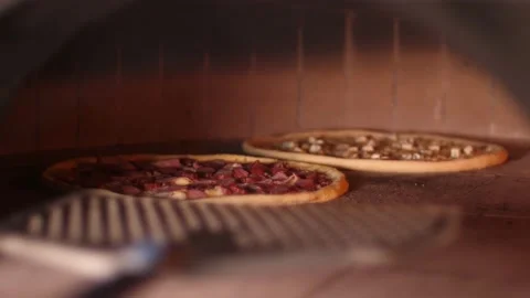 Chef puts to bake pizza in the oven in pizzeria near open fire of burning wood Stock Footage 159227722
