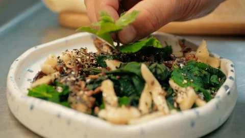 Chef puts a branch of mint on a salad in a restaurant kitchen. cooking salad Stock Footage 92937890
