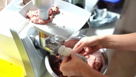 Chef puts the casing for stuffing sausages on the attachment for the meat Stock Footage 268822028