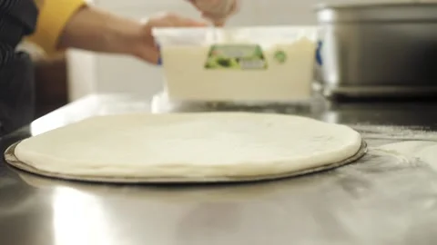 Chef puts cheese sauce on the pizza dough Stock Footage 130558098