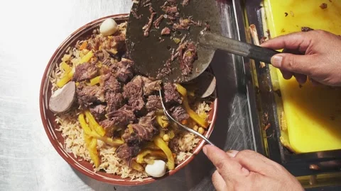 The chef puts the chopped meat in a plate with pilaf and carrots Stock Footage 254661064