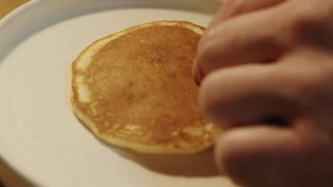 Chef puts cooked fried pancake on elegant white plate in slow motion Video stock 151361633