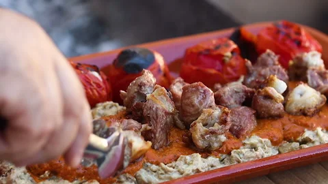 Chef puts the cooked meat on a plate with vegetables. Turkish cuisine Video stock 196511575