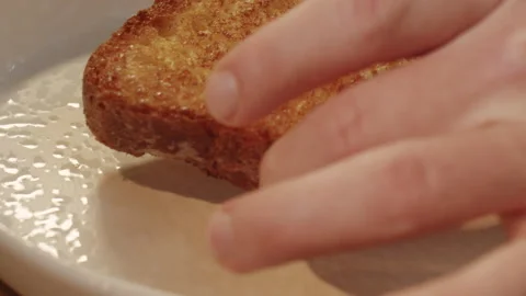 Chef puts crispy brioche bread toast on an white plate in slow motion 스톡 동영상 150840655