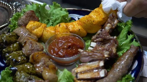 The chef puts on a dish cooked chicken, kebabs, beef ribs, sarma Stock Footage 124727796
