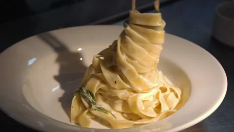 The chef puts the finished pasta with salmon on a plate Stock Footage 158020308