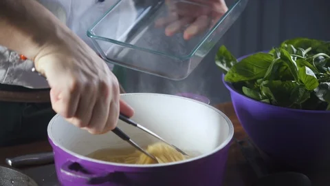 Chef puts finished spaghetti pasta from pan into a plate in restaurant kitchen. Stock-Footage 124709915
