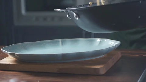 Chef puts finished spaghetti pasta from pan onto a plate in a restaurant kitchen 库存影片 124711012