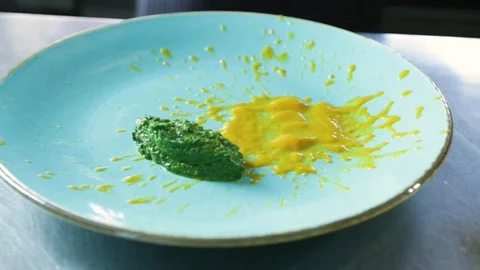 The chef puts finished the spinach on a plate with a sauce bisque Stock Footage 109471294
