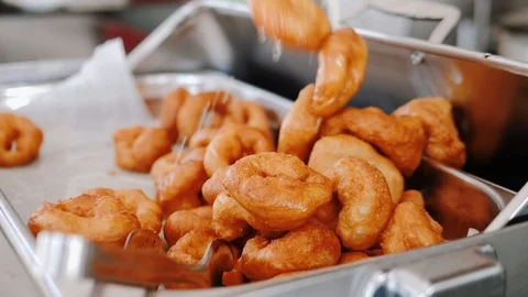 Chef puts fresh crispy donuts on food tray. Sweet and tasty donuts in restaurant Stock Footage 111461341