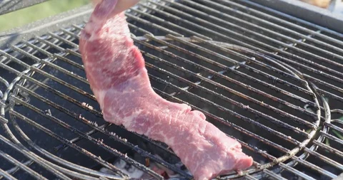 Chef puts fresh meat on the grill Stock Footage 107325921