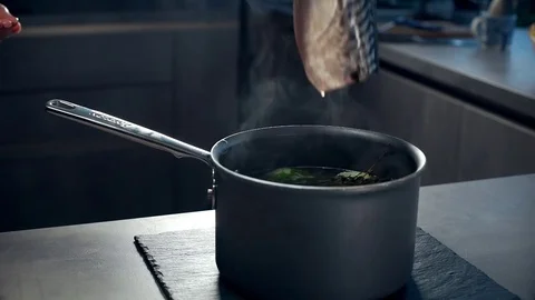 Chef puts fresh pink salmon to the pan with broth, cooking of fish dish, healthy Stock Footage 72979996