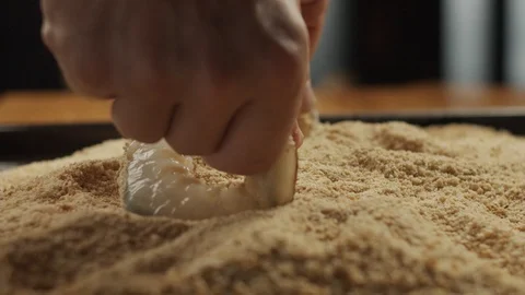 Chef puts fresh shrimp in breadcrumbs on the kitchen table. Slow motion video Stock Footage 116162791
