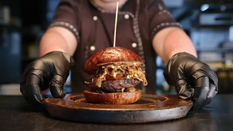 The chef puts a freshly prepared burger on the table. slow motion Stock Footage 235054976