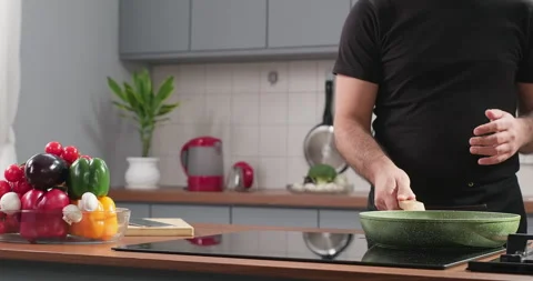 Chef puts frying pan on induction stove. Starting to cook vegetarian food at Stock Footage 252377764