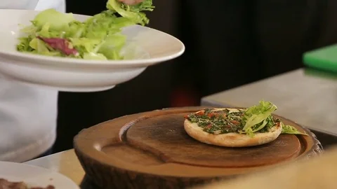 Chef puts green lettuce leaf on a burger bread Video stock 74716056
