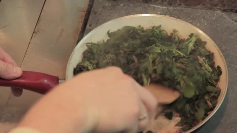 The chef puts the leaves of the nettle into the pan in restaurant kitchen. Chef Stock Footage 131335948