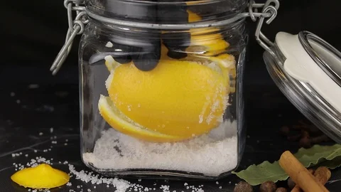 The chef puts the lemon in a rectangular glass jar of salt Stock Footage 123080295