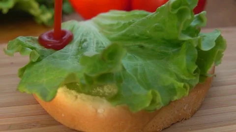 Chef puts lettuce leaf on a bun Stock Footage 74108032
