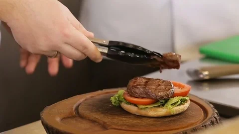 Chef puts meat on a burger bread Stock Footage 74716067