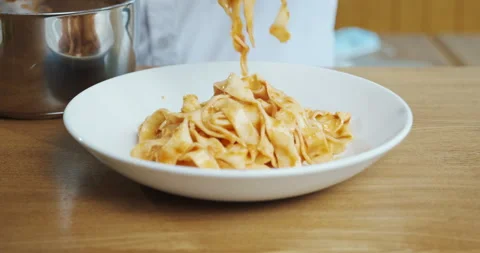 Chef puts pasta spaghetti in the plate with tongs, serving italian dish. Stock Footage 133240907