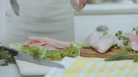 Chef puts a piece of chicken, a chicken leg on a table, on a wooden board Stock Footage 68721376