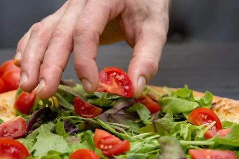 The chef puts on a piece of pizza red tomato, pizza cooking Фото