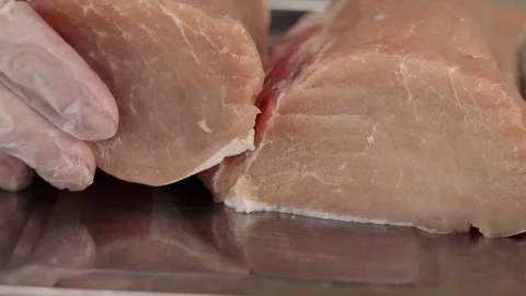 Chef puts a piece of raw pork Stock Footage 122107003