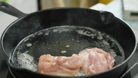 The chef puts pieces of chicken in the pan. Stock Footage 247895378