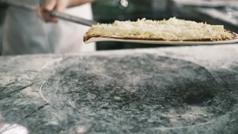 The chef puts the pizza in the oven for baking. Baking pizza in fast food Video stock 199214902