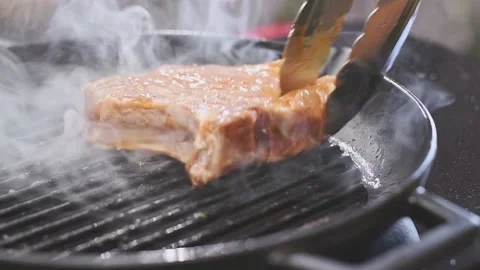 Chef puts pork chop on a grill pan. Stock Footage 159401279