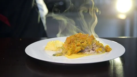 Chef puts portion of delicious hot fish under pumpkin curry on a plate. Stock Footage 88944771