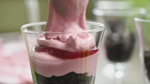 The chef puts the raspberry cheese cream in the jar with a spoon. Stock Footage 200810747