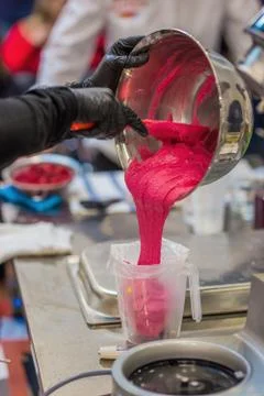 Chef puts raspberry cream in the culinary package, cooking macaroons French Foto stock