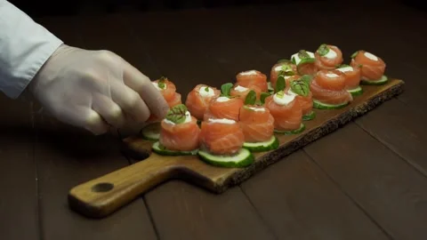 The chef puts red fish with creamy sauce on a cutting board. Stock Footage 143196164