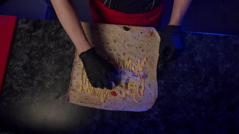 The chef puts the salad on the pita bread covered with sauce Stock Footage 172494594