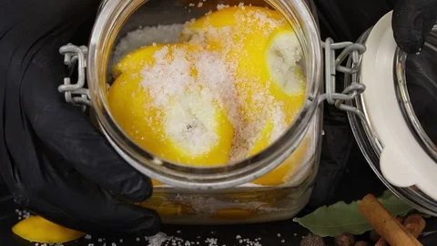 Chef puts salt in a jar of lemons Stock Footage 123116984