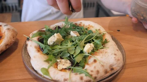 Chef puts seeds on pizza with arugula and Dor blue cheese Stock Footage 132474061