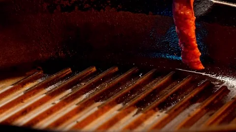 Chef puts slice of fresh meaty stake on the heated grill for BBQ Video stock 156798130