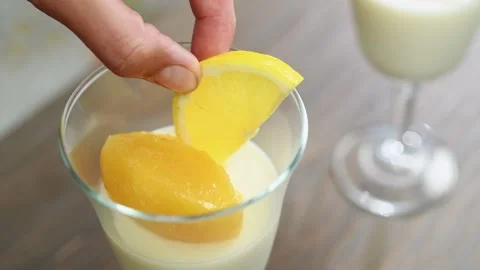 The chef puts a slice of lemon on the freshly prepared lemon curt panna cotta. Stock Footage 198534336