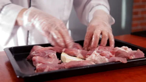 Chef puts the sliced meat on a baking sheet Stock Footage 87049368