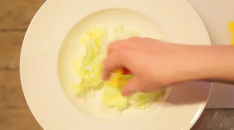 Chef puts sliced vegetables on a plate Stock Footage 61157270