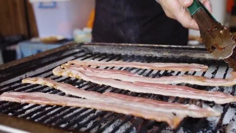 Chef puts slices of fresh raw bacon on the frying pan surface with oil. 스톡 동영상 334642319