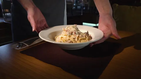 The chef puts the spaghetti and bacon on a plate Stock Footage 158004834