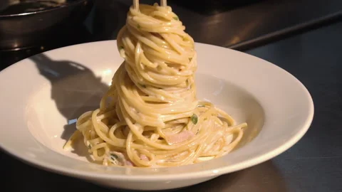 The chef puts the spaghetti and bacon on a plate Stock Footage 158004836