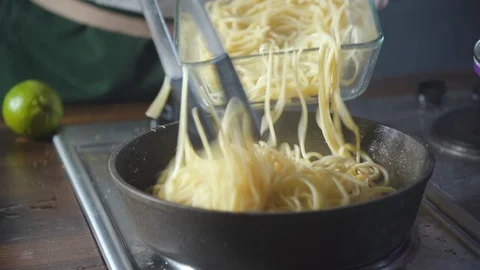 Chef puts spaghetti pasta in a pan with fried salmon in a restaurant kitchen. Stock-Footage 124710116