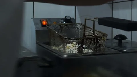 The chef puts squid in a metal mesh deep fat fryer with his gloved hands. Stock Footage 141306012
