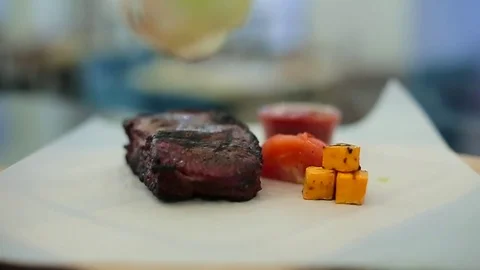 Chef puts steak and vegetables Stock Footage 71802734