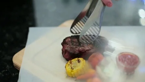 Chef puts steak and vegetables Stock Footage 71803181